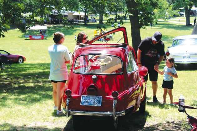 Abby Thompson, 12; Sarah Thompson; Ken Thompson; and Cora Thompson, 4, all of Tecumseh, look over a 1958 BMW Isetta 300, owned by Philip Farmer for the last 25 years. The Isetta won “Most Unusual” in the 36th Annual Knights Auto Club Car Show, held at Boy Scout Park on June 24. The event attracted more than 200 vehicles. Countywide &amp; Sun/Natasha Dunagan