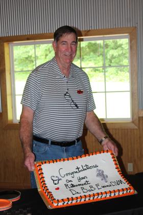 Dr. Bob Evans, DVM, holds up his retirement cake during a reception at Crossing Hearts Ranch on May 21. Evans founded Tecumseh Veterinary Clinic in 1978. Countywide & Sun/Natasha Dunagan