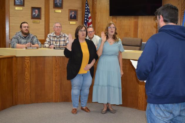 Newly-elected Shawnee Public Schools Board of Education members Mandy Hillhouse, left, Office 4, and Jeanne Swinney, Office 2, take their oath of office as led by Board President Clif Harden during a special board meeting on Friday. Photo provided by Cherity Pennington.