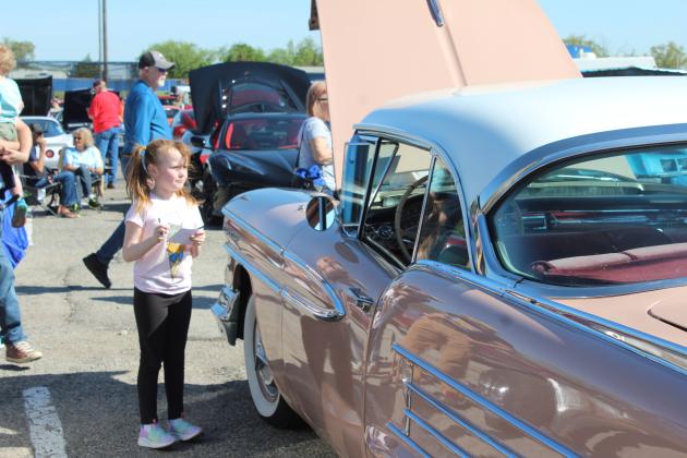 Brynley Stroud, 6, of McLoud, takes down the information from a 1958 Oldsmobile Holiday Coupe, belonging to Gayla Hays, so she can vote for it to receive the Kids Choice Award. The pink and white coupe was one of 136 vehicles in the Eighth Annual Bethel Band Boosters Car Show Fundraiser on April 13. Countywide & Sun/Natasha Dunagan