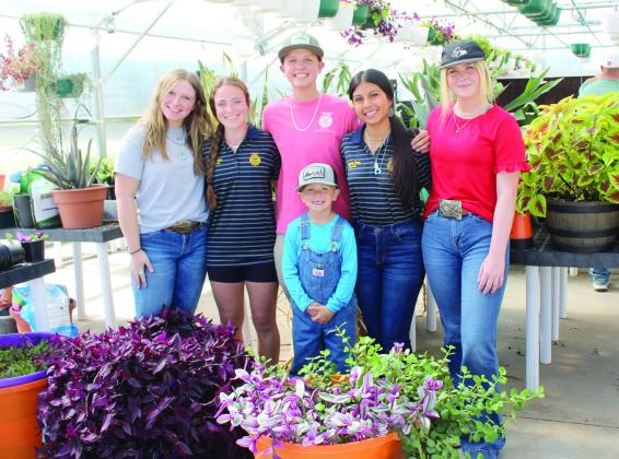 Several McLoud FFA students (and a little brother) were ready to help customers at their first plant sale, Oct. 19-20, since their new climate-controlled greenhouse was built. They offered mums in several colors at the sale, as well as tulip bulbs from a business in Harrah. Horticulture students have also grown wax begonias, succulents, coleus, potato vine, wandering jews, Swedish Ivy and potato vines, which will be offered at their sale in April. (See longer cutline below.)