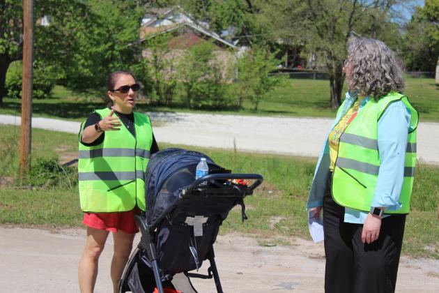 Ronnelle Baker, with Sooner Success, left, tells Holly Gordon, from the TSET Healthy Living Program, about  the challenges of pushing her 2-year-old son in a stroller during the Tecumseh Walking Audit on April 12. Countywide & Sun/Natasha Dunagan